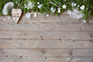 Christmas wooden background with fir branches and white decor, snowflakes, beads, hearts, copy space