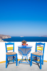 Fototapeta na wymiar Blue chairs and table on a mediterranean balcony with nice view