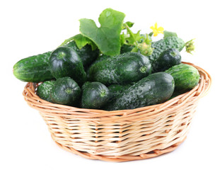 Wicker basket with cucumbers isolated on white