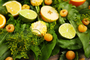 Fototapeta na wymiar Yellow fruits and green herbs background