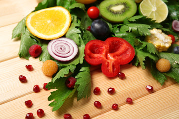 Cute colourful bouquet of sliced vegetables on wooden background, close up