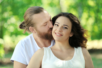 Obraz premium Portrait of embracing couple in the park, close up