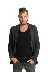 Fototapeta premium A man wearing a black shirt and grey sweater standing against a white background, smiling to camera.