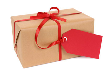 Brown paper package parcel or present one single small tied with red ribbon and gift tag for...