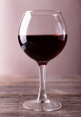 Glass of red wine on wooden table