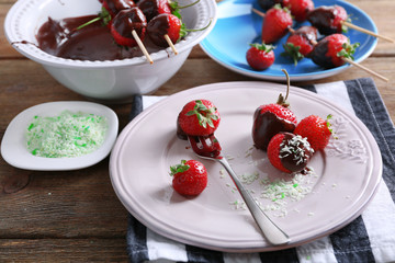 Served table with delicious strawberries in chocolate on wooden background