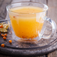 Sea buckthorn tea for health.Autumn still life on wooden background.