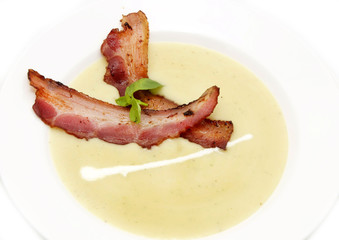 pea soup with bacon on a white plate