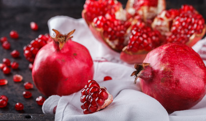 Juicy pomegranates,whole and broken on a dark background.selective focus.