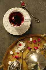 Cup of rose tea with sugar on wooden table