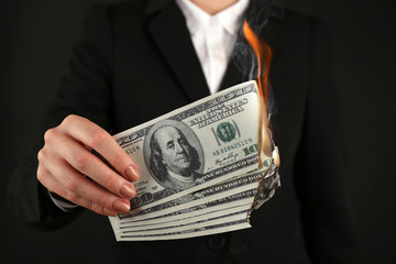 Woman burning  dollars closeup