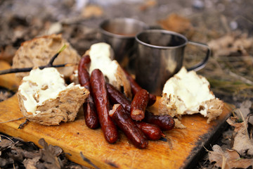 Grilled sausages on cutting board in the wood