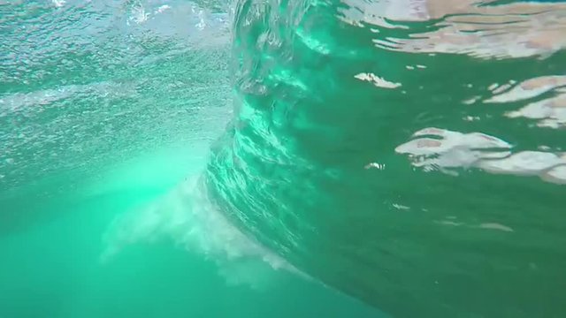UNDERWATER SLOW MOTION: Beautiful big tube wave breaking over camera