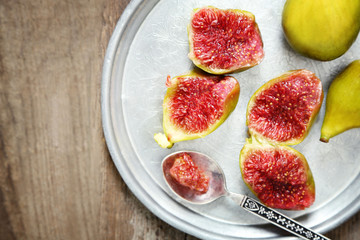 Ripe figs on tray, on wooden background