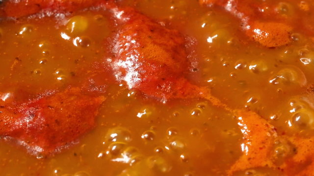 Boiling spicy mexican chili pepper hot sauce in pot