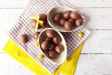Chocolate Easter eggs on white wooden background