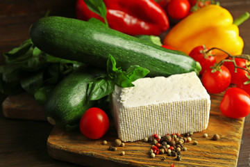 Fresh ingredients for preparing zucchini rolls on wooden background