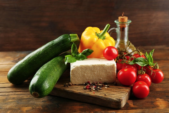 Fresh ingredients for preparing zucchini rolls on wooden background