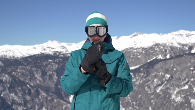 Snowboarder girl putting on gloves