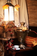 Samovar with a cup of tea. / Cup of tea and a Russian samovar under the light of a lantern. Autumn.