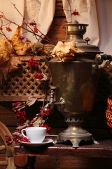 Samovar with a cup of tea. / Cup of tea and a Russian samovar under the light of a lantern. Autumn.