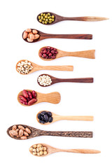 Assortment of beans and lentils in wooden spoon isolate on white