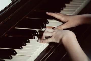 Fototapeta premium Close up of little girl hands piano playing