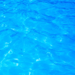 Blue pool water with sun reflections