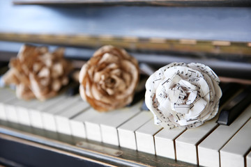 Vintage old classic piano with paper rose and musical notes on it, close up