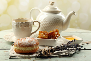 Honeycomb, bowl with honey, teapot on color wooden background