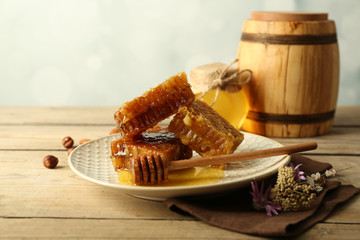 Honeycombs on plate on wooden background