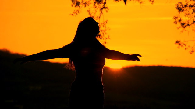 SLOW MOTION: Young woman spinning at sunset