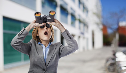 young business woman looking through the binoculars