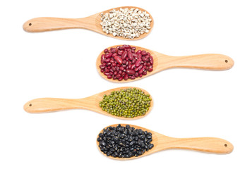 Job's tears, Kidney beans, Mung beans and Black beans with wooden spoon isolated on white.