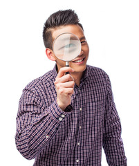portrait of a young asian man looking through a magnifying glass