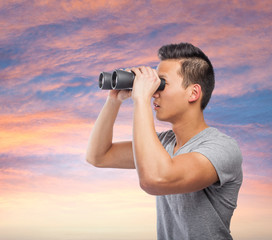 handsome young asian man looking through a binoculars