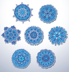 Vector Snowflake, set. Image of seven blue snowflakes with different ethnic patterns on a light background.