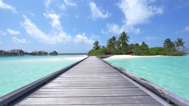 SLOW MOTION: Water villas in front of exotic white sand beach 
