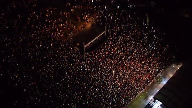 AERIAL: Crowd of people dancing on a music festival