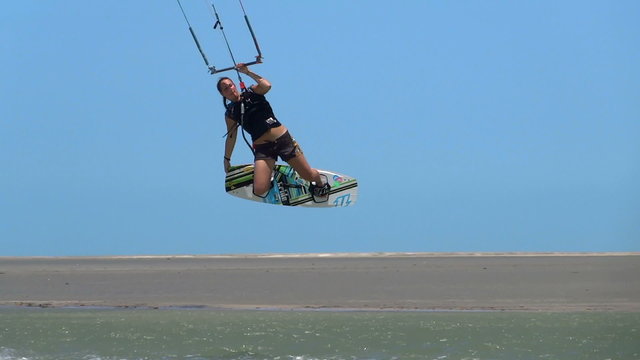 Female kiteboarder performs a trick