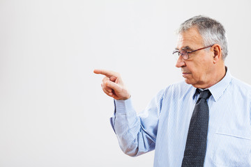 Portrait of senior businessman pointing