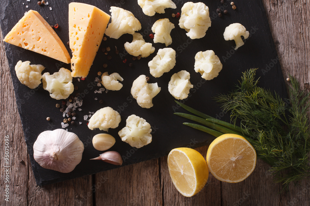 Wall mural Preparation of cauliflower for baking with ingredients Horizontal top view 
