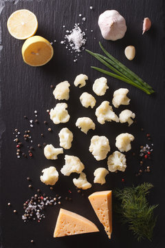 Cauliflower with ingredients on a stone table. Vertical top view 
