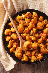 Asian food: cauliflower in curry sauce close-up. vertical top view

