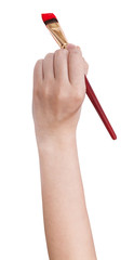 hand holds art flat paintbrush with red paint