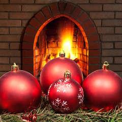 red Xmas baubles on spruce tree with fireplace