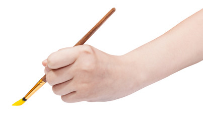 hand holds artistic paint brush with yellow tip