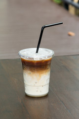 Iced coffee latte in plastic glass on table