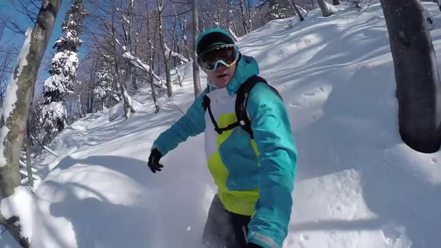 SELFIE: Snowboarder riding powder in snowy mountain forest
