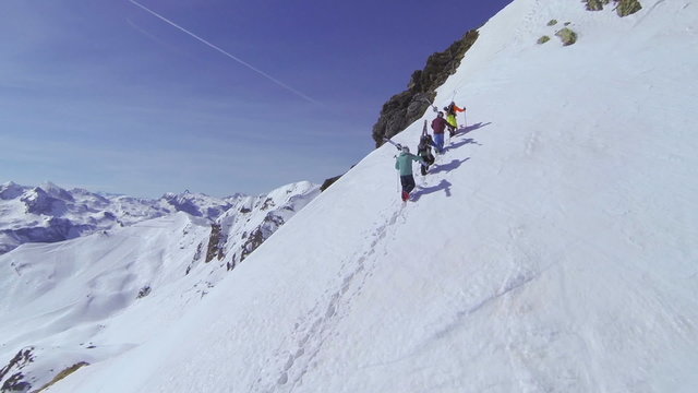 AERIAL: Skiers hiking up big mountain in Austria 